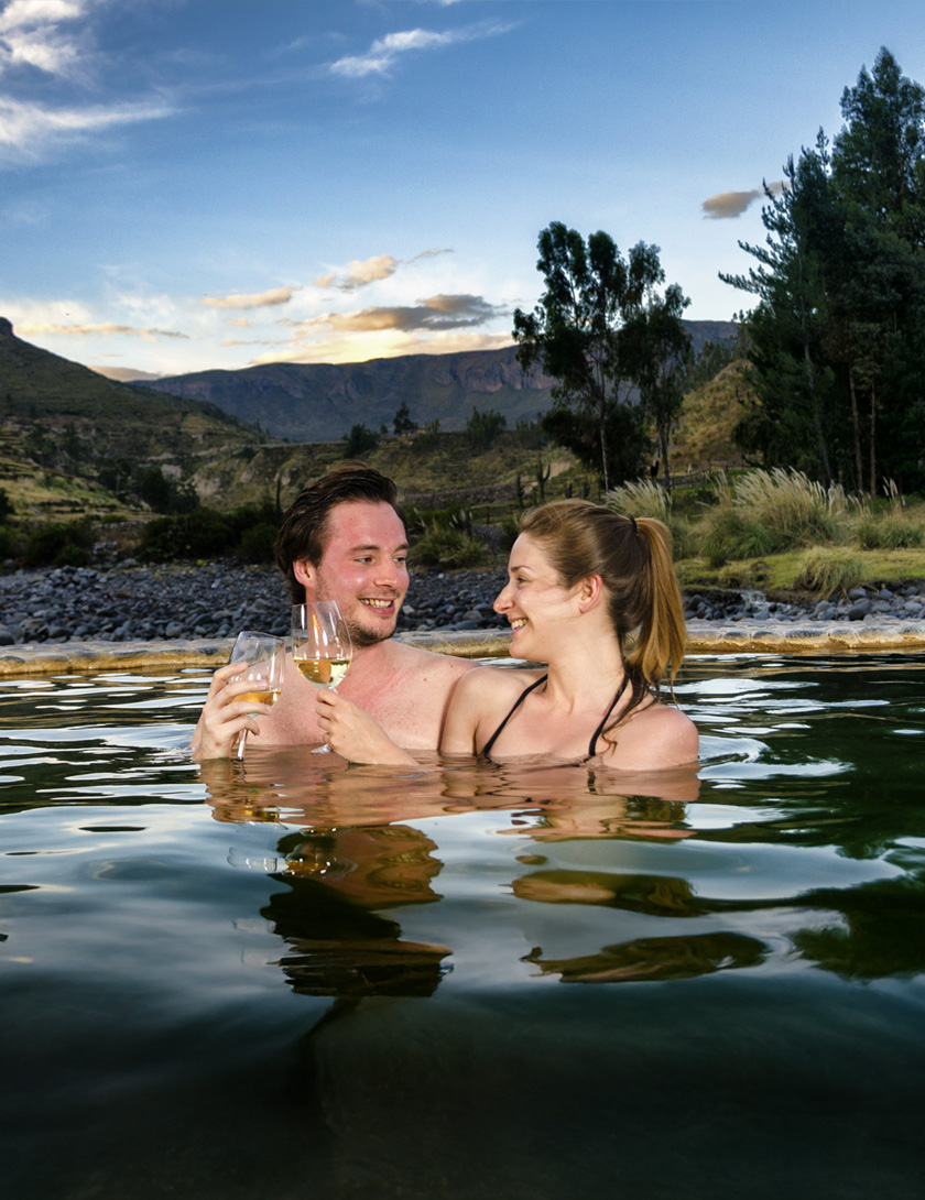 Travellers relaxing in natural hot springs in the Colca Canyon, Peru